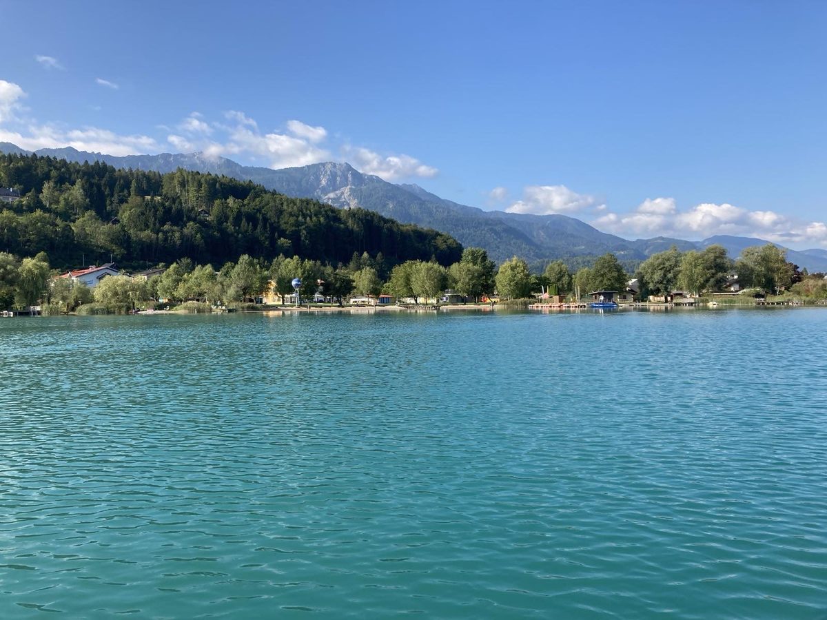 Turquoise water of Lake Faak with mountain panorama