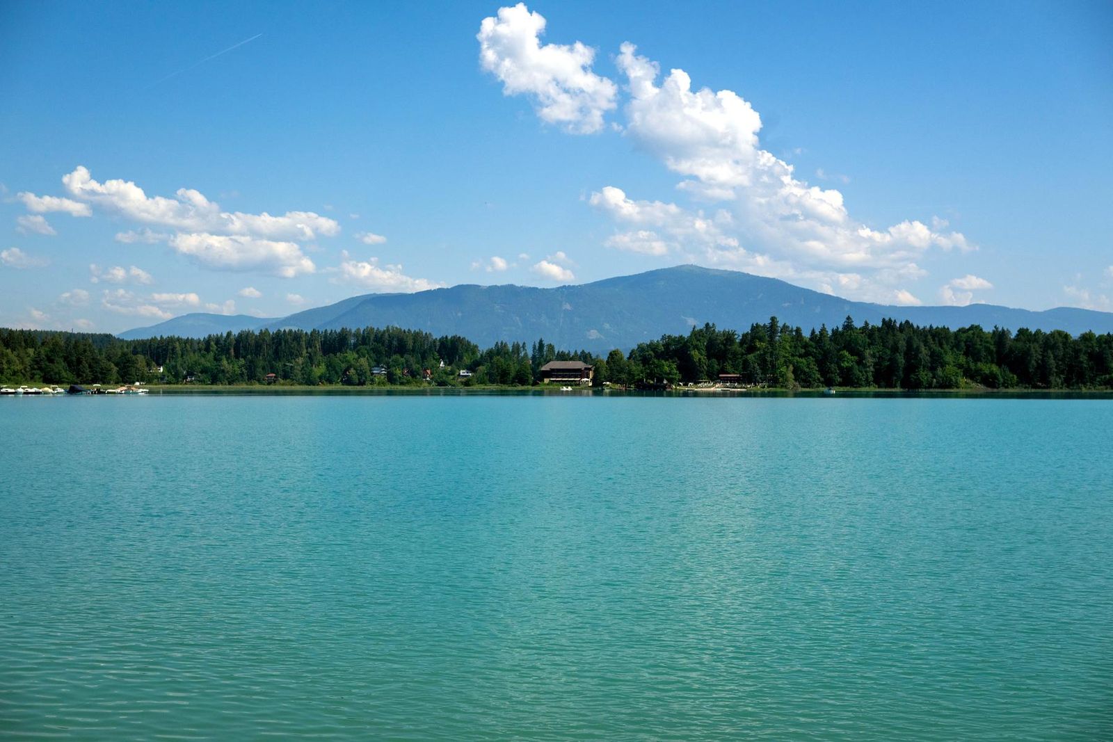 Turquoise Lake Faak with a view of the mountains
