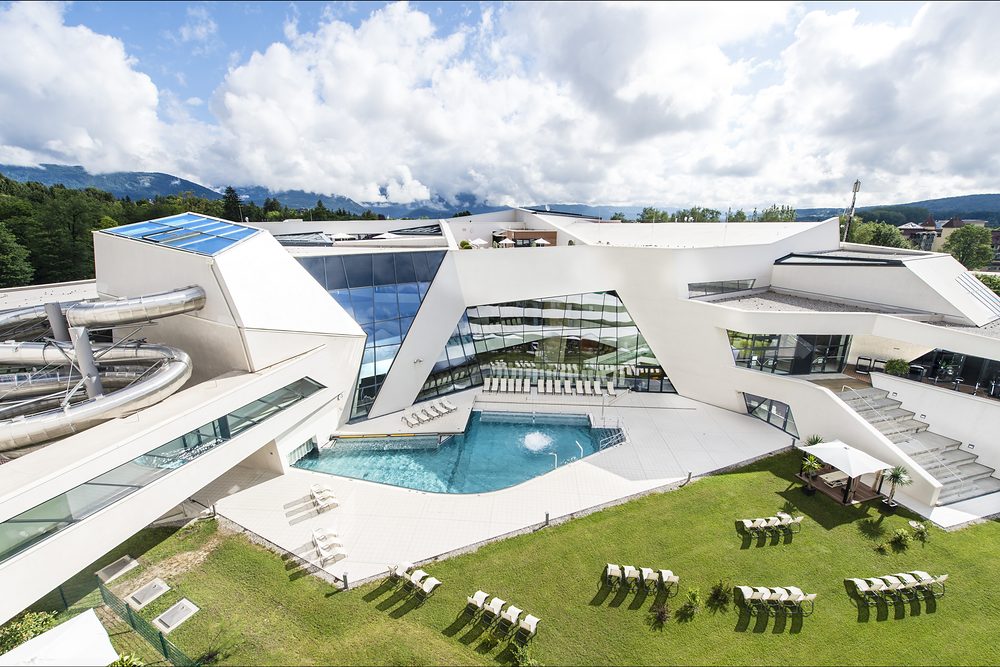 KärntenTherme Warmbad-Villach from outside: outdoor pool, sunbathing lawn and slides
