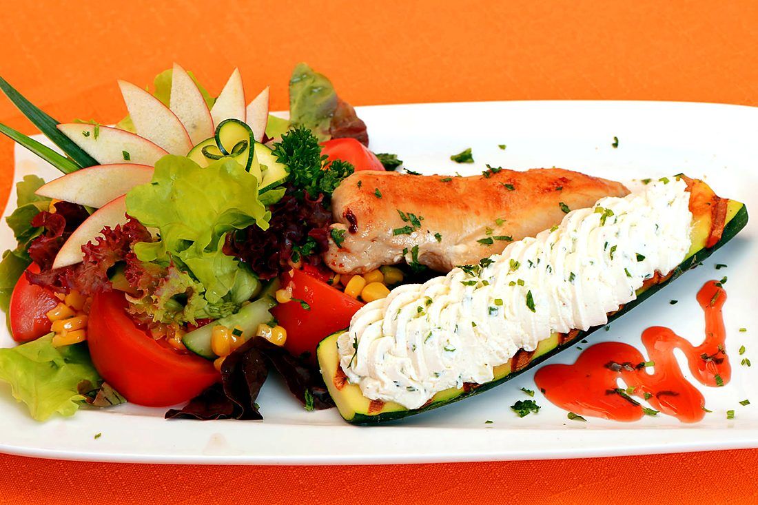 Grilled chicken breast with stuffed courgette and a colourful salad plated up