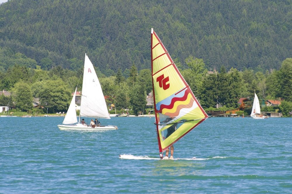 Surfer on Lake Faak against a mountain backdrop